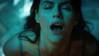 Alexandra Daddario showing cleavage in a bra as we see her having sex riding a guy in bed, at first wearing a necklace that hangs down between her breasts before it magically appears around the guy’s neck instead and she tugs on it while leaning over