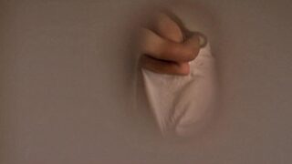 Florence Pugh seen through a keyhole in a door as she kisses a guy while wrapped in a sheet, the sheet falling down to briefly reveal her left breast before she lays back out of view