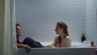 Jessica Chastain sitting in a bathtub as a guy sits down at the edge and she puts her arms around him