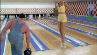 Vanessa Angel of Weird Science fame wearing short yellow shorts and a low cut yellow top that shows a lot of cleavage as she jumps up and down at a bowling alley trying to distract guys eventually having the tops of her nipples pop out and then grabb